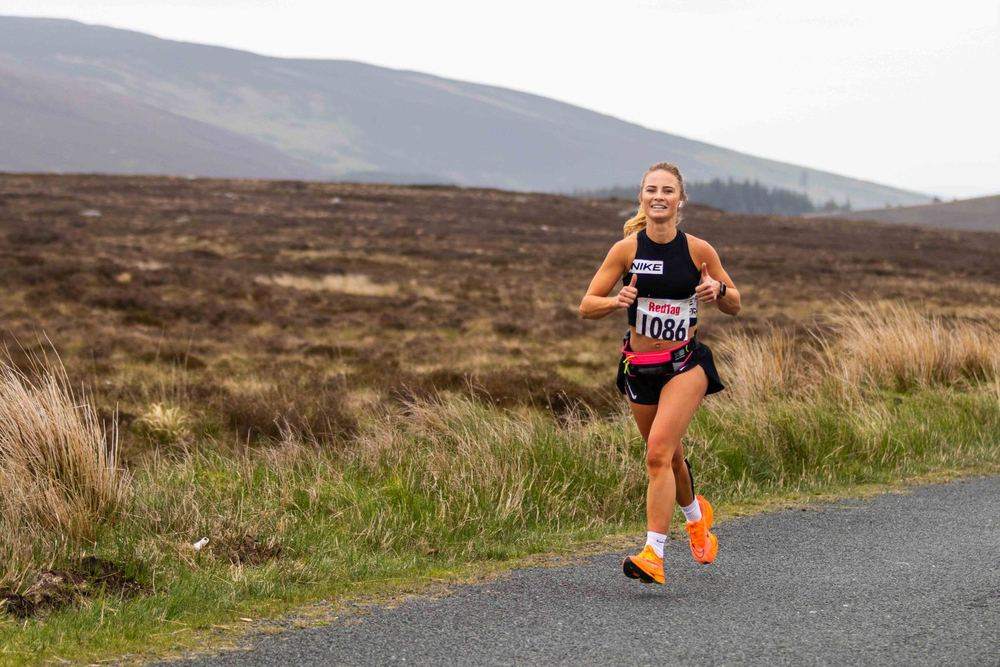 A runner alone on the open bog road above the valley